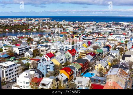 Paesaggio urbano di Reykjavik, Islanda, con case ed edifici residenziali colorati, lago Tjornin e vista sull'oceano nella giornata di sole visto da Hallgrimskirkja ch Foto Stock