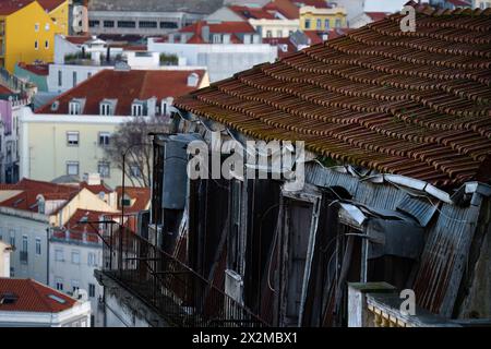 In cima ad un vecchio edificio abbandonato con edifici lontani sullo sfondo Foto Stock