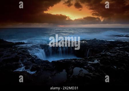 I cieli spettacolari del tramonto si illuminano sopra il Bufadero de la Garita, mentre le turbolente onde si infrangono nelle formazioni rocciose uniche sulla costa di Gran Canaria Foto Stock