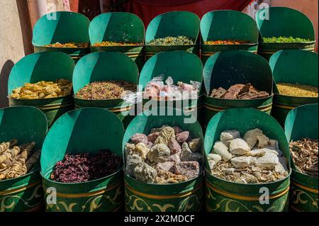 Spezie tradizionali marocchine esposte in grandi ciotole verdi in un mercato locale, che mostrano la ricchezza culinaria del Marocco. Foto Stock