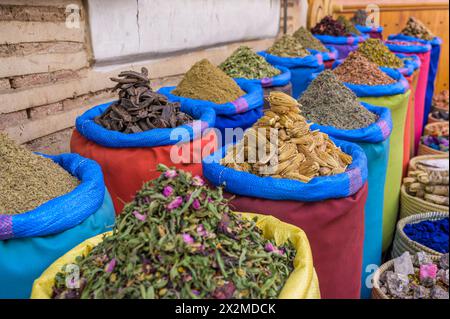 Una gamma di sacchi colorati pieni di varie spezie esotiche è splendidamente allestita in un mercato in Marocco, che mostra le ricche tradizioni culinarie Foto Stock