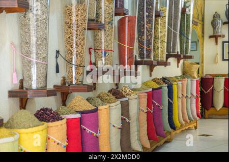Una vivace esposizione di varie spezie in sacchi in un mercato tradizionale in Marocco. Foto Stock