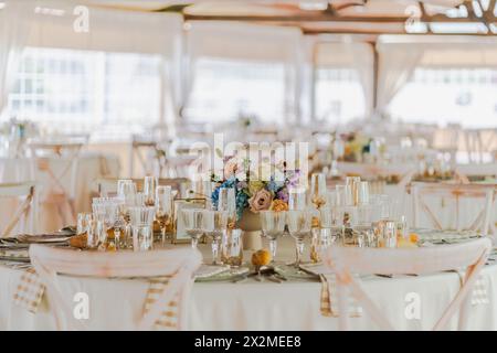 Elegante tavolo per ricevimenti nuziali con centro floreale e raffinata porcellana Foto Stock