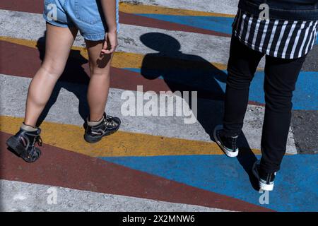 Ombra dell'uomo con cappello e mezzo corpo di donna in pantaloncini irriconoscibili che camminano. Concetto di passeggiate e vacanze Foto Stock