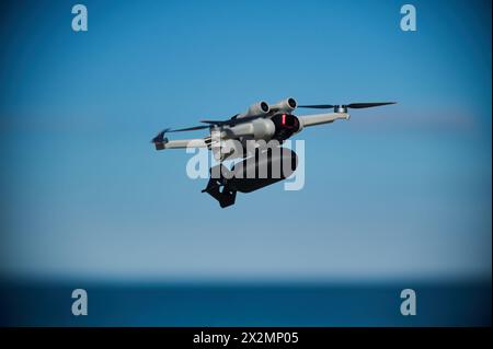 Un drone civile con una piccola bomba a bordo sta volando nel cielo Foto Stock