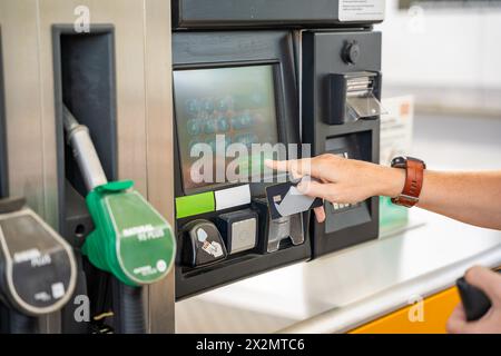 Vista ravvicinata dell'uomo che paga il carburante con una carta di credito sul terminal della stazione di servizio self-service in Europa Foto Stock