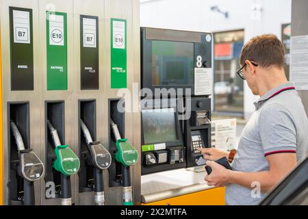 L'uomo paga il carburante con una carta di credito al terminal della stazione di servizio self-service in Europa Foto Stock