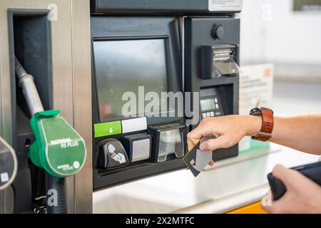 Vista ravvicinata dell'uomo che paga il carburante con una carta di credito sul terminal della stazione di servizio self-service in Europa Foto Stock