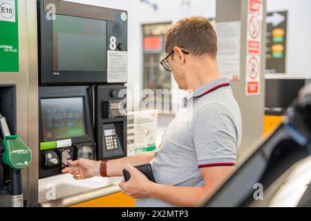 L'uomo paga il carburante con una carta di credito al terminal della stazione di servizio self-service in Europa Foto Stock