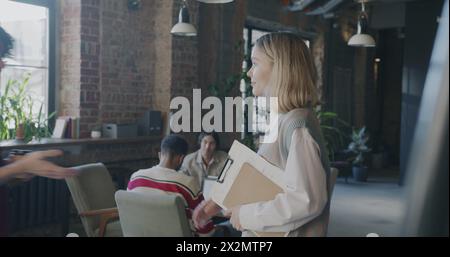 Uomini e donne partner d'affari che si incontrano in ufficio creativo stringendo la mano e parlando. Riunione professionale e concetto di avvio di successo. Foto Stock