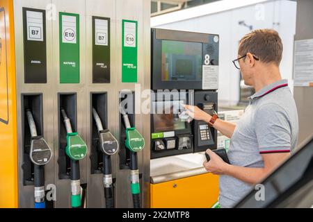 L'uomo paga il carburante con una carta di credito al terminal della stazione di servizio self-service in Europa Foto Stock