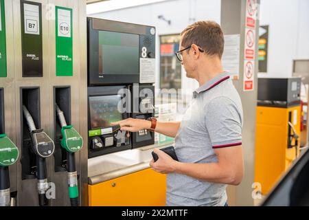 L'uomo paga il carburante con una carta di credito al terminal della stazione di servizio self-service in Europa Foto Stock