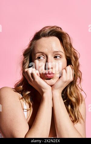 Una donna con le mani sul viso, che esprime profonda emozione e introspezione. Foto Stock