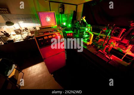Movimento di microparticelle mediante laser in laboratorio buio con timer, monitor, mouse, tastiera Foto Stock