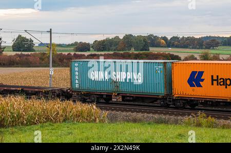 Ein Schiffscontainer von China Shipping und Hapag-Lloyd wird auf einem Güterzug auf der Bahnstrecke zwischen München und Nürnberg durch Deutschland tr Foto Stock