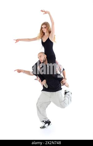 Breakdancer mantiene sulle spalle la ballerina isolata su sfondo bianco. Uomo e donna puntano a sinistra. Foto Stock