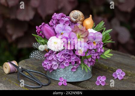 composizione floreale con fiori viola viola viola viola, lilla, perennis bellis, tulipani e rosa quaresimale Foto Stock