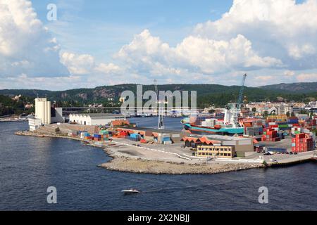 Porta piccola. I container sono a terra. Le gru caricano il carico sulla nave Foto Stock