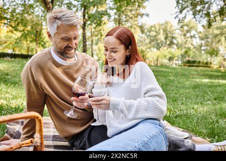 La coppia ama il vino in coperta nel parco. Foto Stock