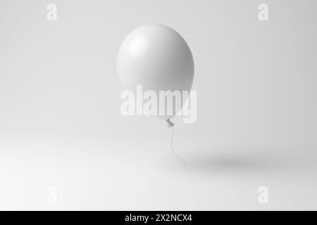 Palloncino bianco con nastro arricciante che galleggia a mezz'aria su sfondo bianco monocromatico e minimalista. Festeggiamenti speciali, feste, felicità Foto Stock