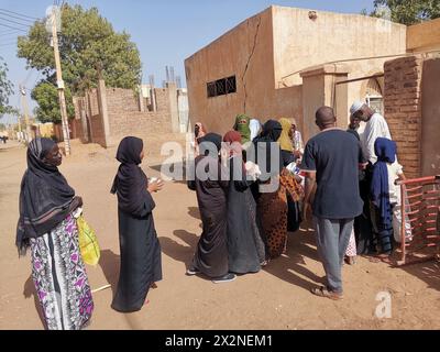 Khartoum. 22 aprile 2024. Questa foto scattata con un telefono cellulare il 22 aprile 2024 mostra gli sfollati in coda per ricevere pasti gratuiti da un ristorante di beneficenza nel quartiere Karari di Omdurman, a nord-ovest della capitale sudanese Khartoum. PER ANDARE CON "Feature: Il Sudan lancia iniziative benefiche per aiutare gli sfollati in mezzo alla guerra civile" credito: Mohamed Khidir/Xinhua/Alamy Live News Foto Stock