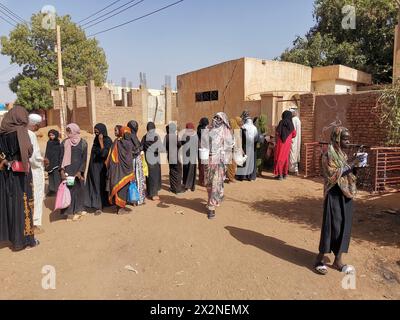 Khartoum. 22 aprile 2024. Questa foto scattata con un telefono cellulare il 22 aprile 2024 mostra gli sfollati in coda per ricevere pasti gratuiti da un ristorante di beneficenza nel quartiere Karari di Omdurman, a nord-ovest della capitale sudanese Khartoum. PER ANDARE CON "Feature: Il Sudan lancia iniziative benefiche per aiutare gli sfollati in mezzo alla guerra civile" credito: Mohamed Khidir/Xinhua/Alamy Live News Foto Stock