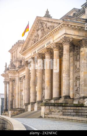 L'edificio del Reichstag di Berlino, adornato da colonne e bandiera tedesca, catturato dalla luce soffusa della mattina presto. Berlino, Germania Foto Stock