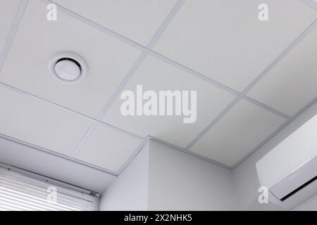 Soffitto bianco con piastrelle in PVC per interni, vista ad angolo basso Foto Stock