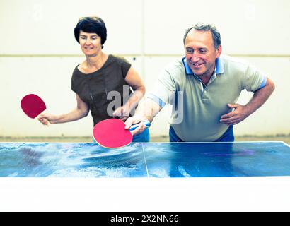 Felice matura spousesn giocare a ping pong Foto Stock