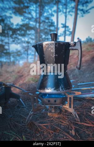 Macchina per il caffè tradizionale. Macchina per il caffè da campeggio. Macchina per il caffè espresso su un piano cottura in un campeggio. Foto di viaggio. Primo piano. Foto Stock