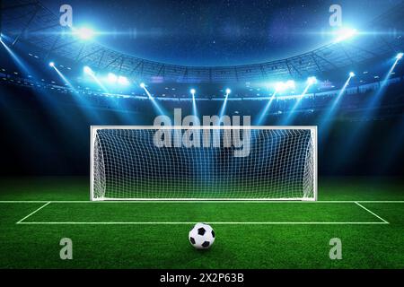 Splendido stadio di calcio con campo verde, pallone, gol e proiettori illuminati di notte con stelle. Campionato di calcio e rigori. Gioco ed ecc Foto Stock