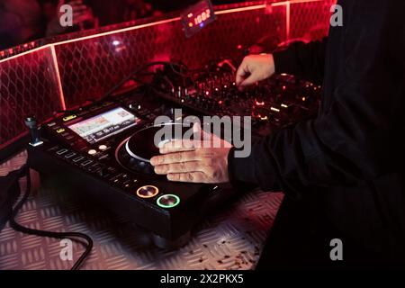 Vista ravvicinata delle mani di un dj che suona il mixer durante l'esecuzione Foto Stock