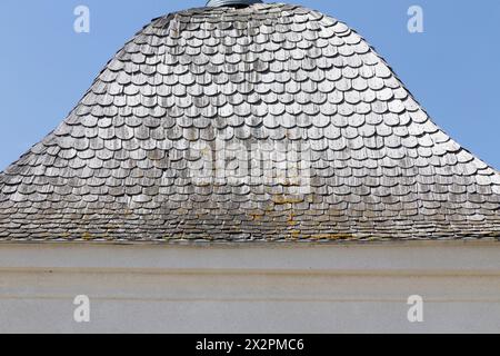Vecchie tegole di legno sul tetto della capanna. Cielo blu sullo sfondo. Primo piano. Foto Stock