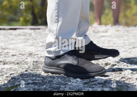 Piedi umani in scarpe su una superficie di pietra. Primo piano. Foto Stock