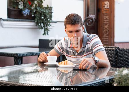 Un giovane legge le notizie sul dispositivo Foto Stock