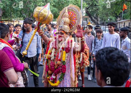 Un devoto vestito come il dio indù Hanuman, posa per le foto durante la processione Hanuman Jayanti a Connaught Place. Hanuman Jayanti è un festival indù che celebra la nascita di Lord Hanuman, una delle divinità più venerate dell'induismo. Foto Stock