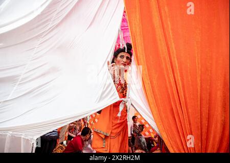 Nuova Delhi, India. 23 aprile 2024. Un devoto vestito come Lord Rama, guarda fuori da un'area di trucco coperta prima della processione Hanuman Jayanti a Connaught Place. Hanuman Jayanti è un festival indù che celebra la nascita di Lord Hanuman, una delle divinità più venerate dell'induismo. (Foto di Pradeep Gaur/SOPA Images/Sipa USA) credito: SIPA USA/Alamy Live News Foto Stock