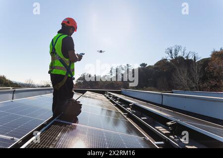 Drone volante ingegnere maturo in piedi accanto al pannello solare Foto Stock