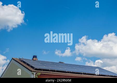Pannelli solari sul tetto della casa sotto il cielo blu nuvoloso in Baviera, Germania Foto Stock