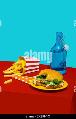 Cheeseburger con patatine fritte vicino alla bottiglia di bibita sul tavolo su sfondo blu Foto Stock