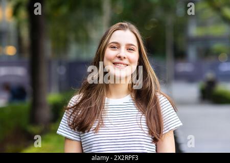 Giovane donna sorridente che indossa una t-shirt a righe Foto Stock