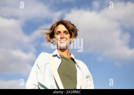 Donna matura sorridente sotto il cielo Foto Stock