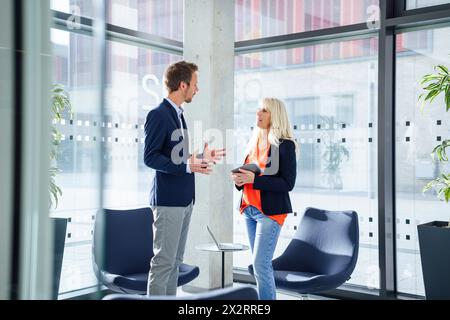 Imprenditore discutendo con imprenditrice in office Foto Stock