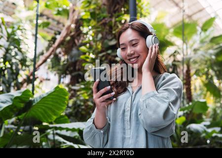 Giovane donna che ama ascoltare musica con le cuffie wireless Foto Stock