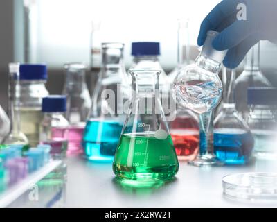 Mano dello scienziato che mescola il campione chimico in una fiasca di laboratorio Foto Stock