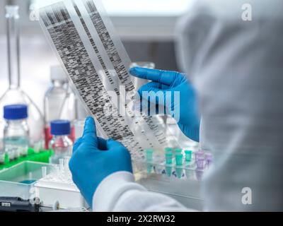 Scienziato che esamina l'autoradiogramma del DNA in laboratorio Foto Stock