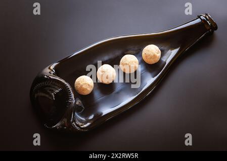 cioccolato bianco al tartufo di caramelle su un piatto di vetro a base di una bottiglia fusa Foto Stock