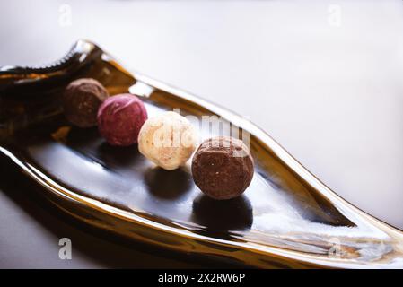 caramelle multicolore al tartufo su un piatto di vetro realizzato con una bottiglia fusa Foto Stock