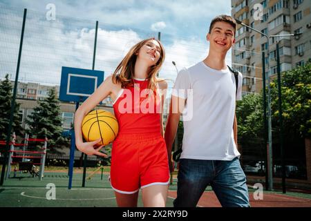 Amici di scuola che si tengono per mano e camminano nel cortile della scuola Foto Stock