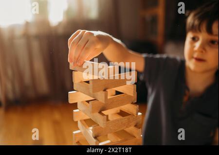 Ragazzo che impilava i blocchi e giocava a casa Foto Stock